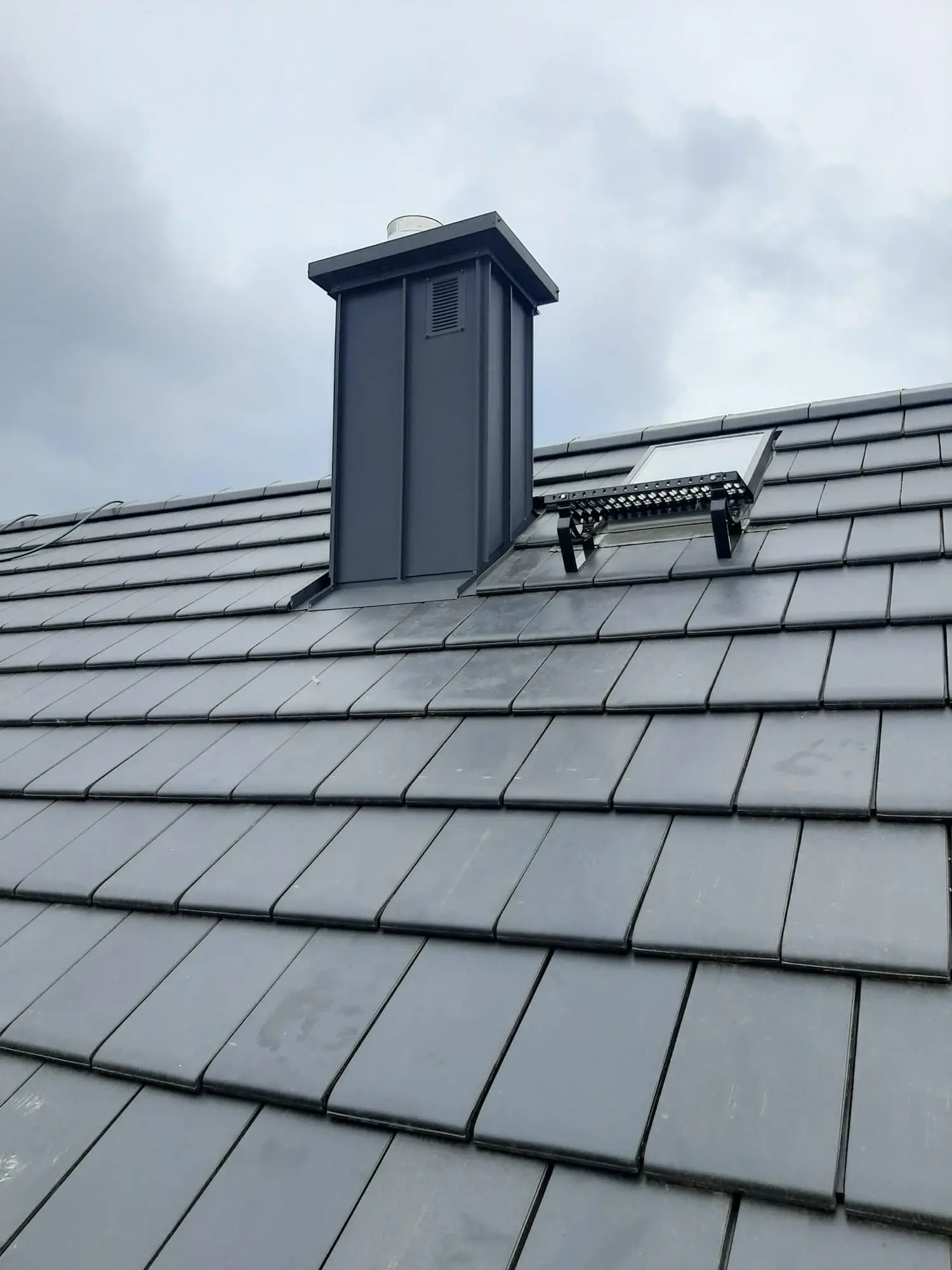 Pokrycie dachowe z obróbką blacharską przy kominie po zakończeniu prac