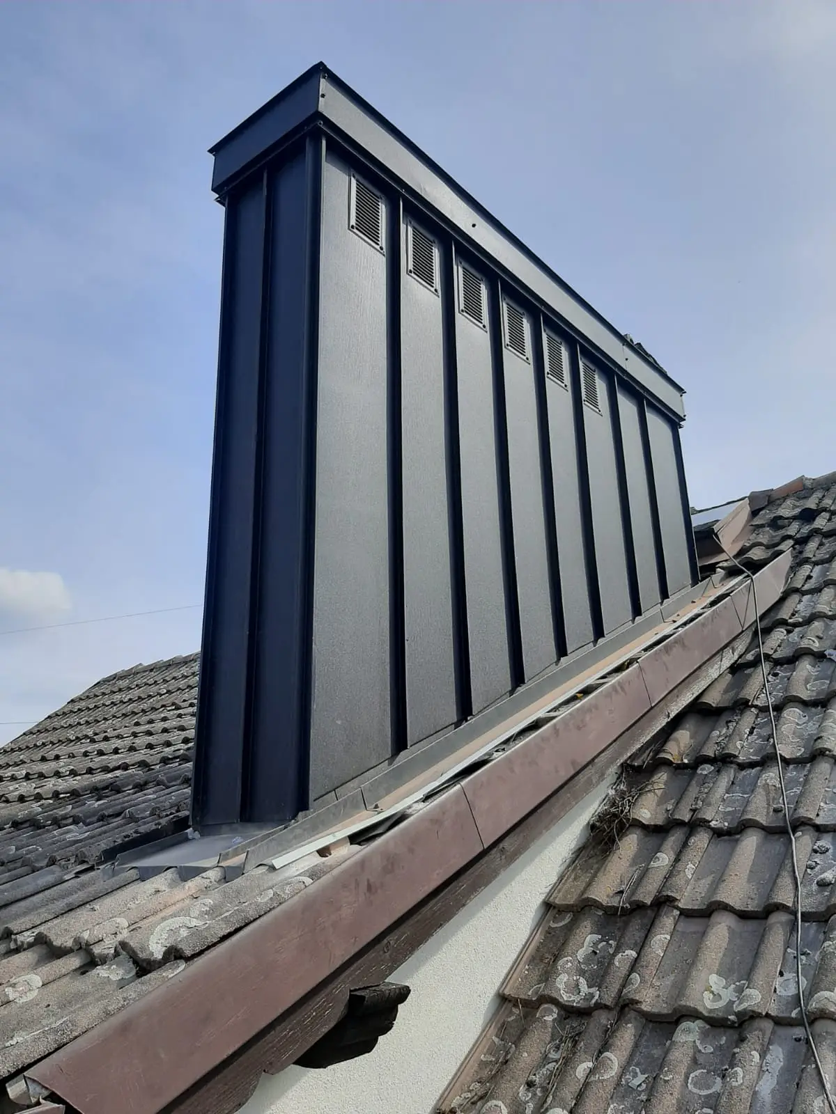 Duży komin po wykonaniu opierzenia i uszczelnienia blacharskiego